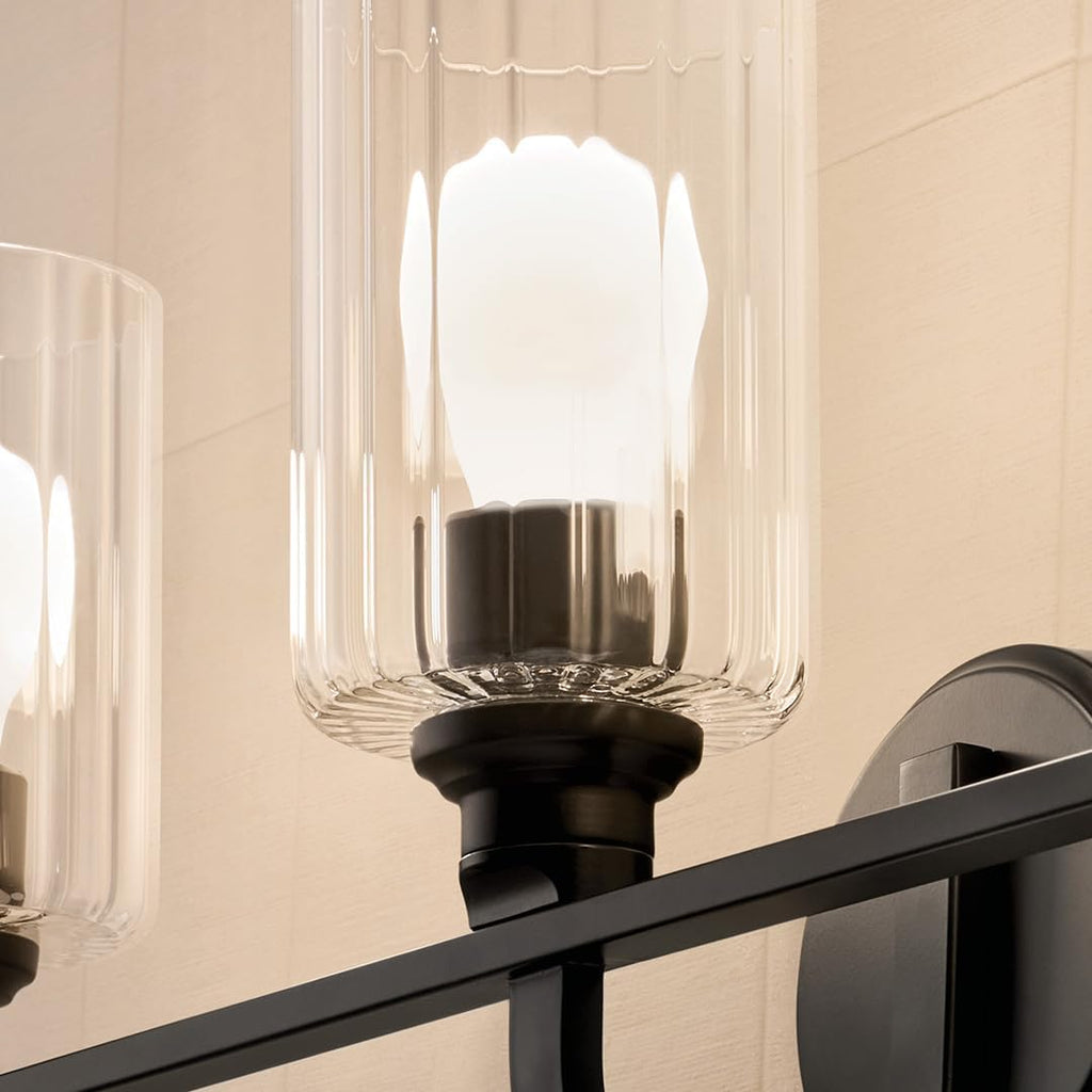 Kichler Gioe 24.25' 3-Light Bathroom Vanity Light Fixture with Clear Fluted Glass in Black, Modern Wall Mount Over Mirror for Powder Room, Damp Rated (24.25' W x 10.5' H), 55226BKFLU
